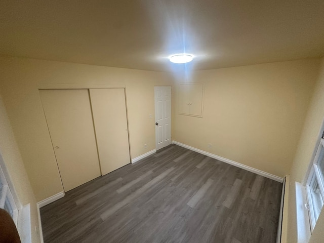 unfurnished bedroom featuring a closet and dark hardwood / wood-style floors