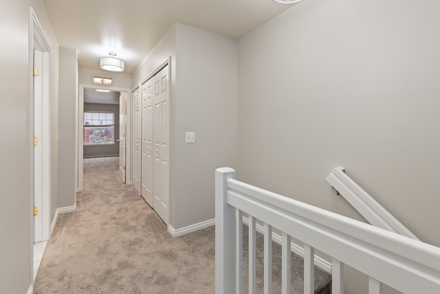 hall featuring light colored carpet