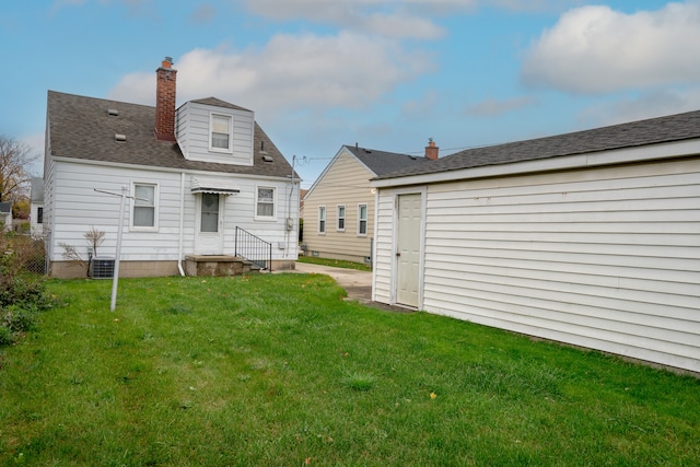 back of property featuring a lawn and central AC