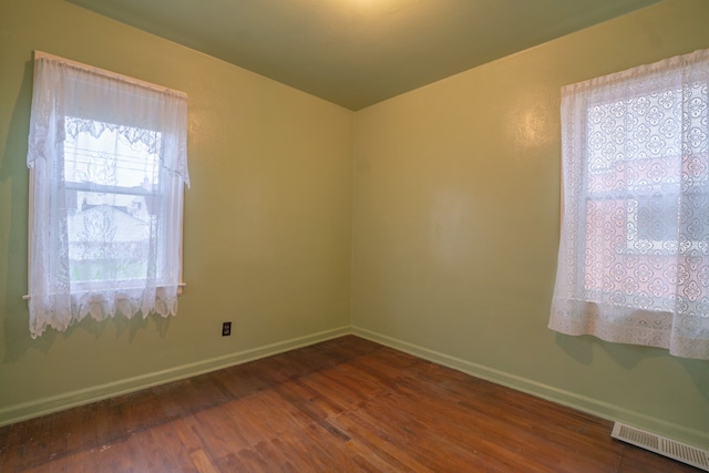 empty room with dark hardwood / wood-style flooring