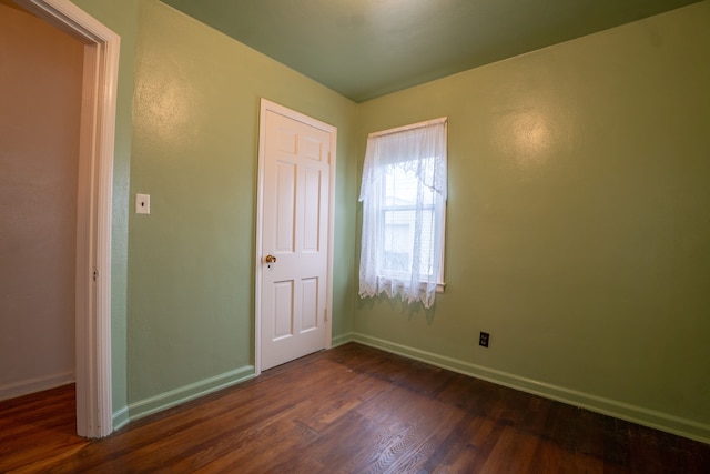 unfurnished bedroom with a closet and dark hardwood / wood-style floors