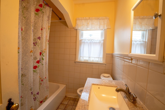 full bathroom featuring tile patterned floors, a wealth of natural light, tile walls, and toilet