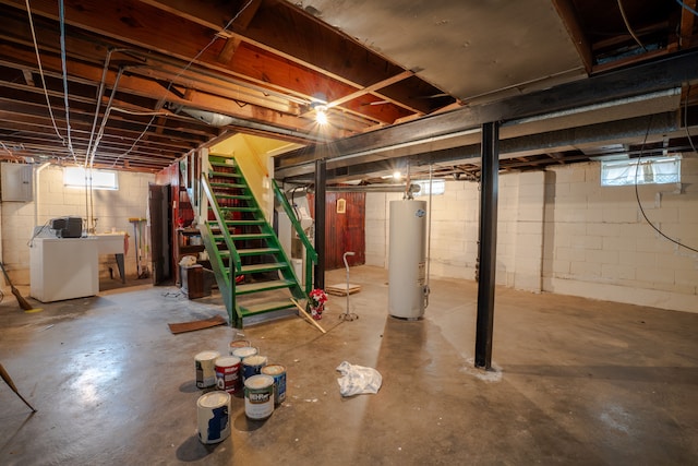 basement featuring electric panel, washer / clothes dryer, and water heater