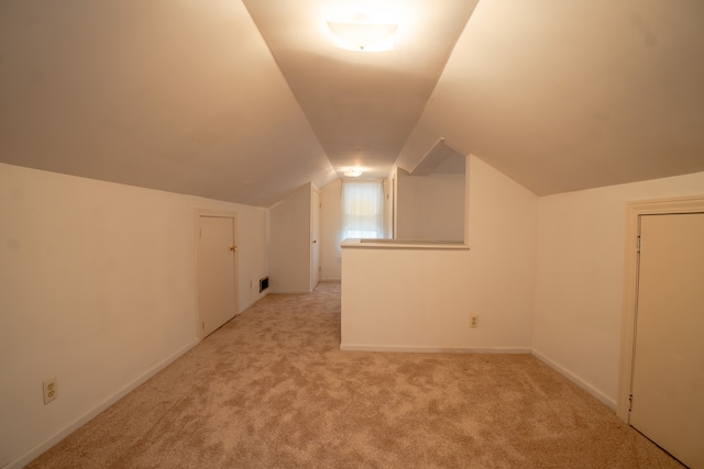 additional living space with light colored carpet and lofted ceiling