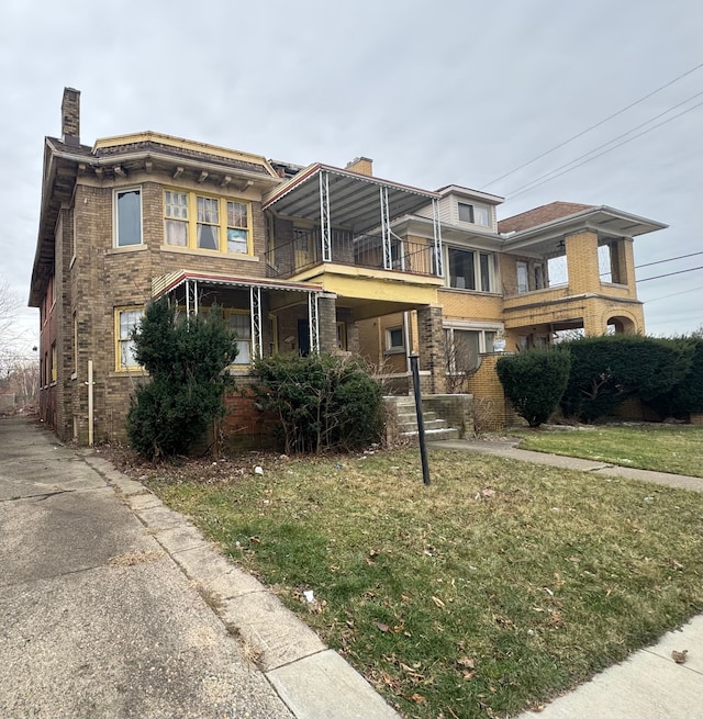 view of front of property with a balcony and a front lawn