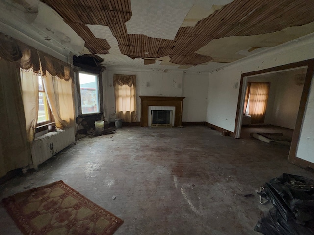 miscellaneous room featuring radiator heating unit, a fireplace, and concrete flooring