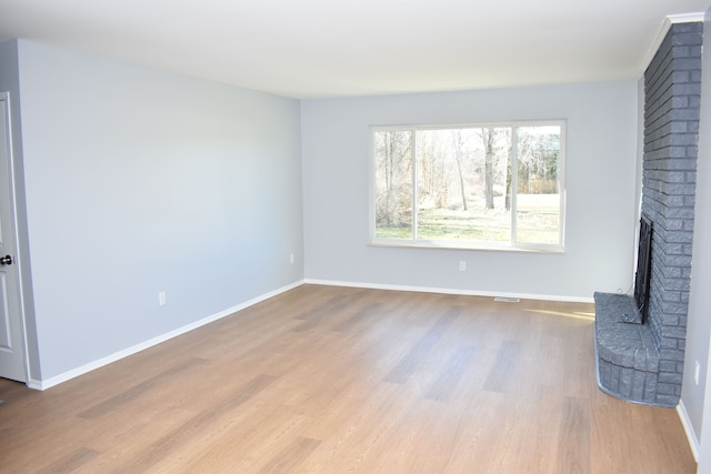 unfurnished living room with a fireplace and light hardwood / wood-style flooring