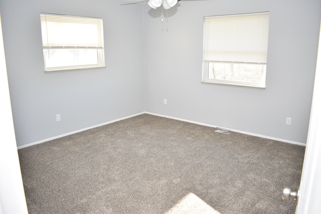 spare room featuring a wealth of natural light, carpet, and ceiling fan