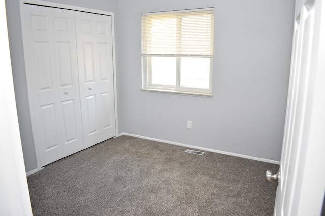 unfurnished bedroom featuring carpet flooring and a closet