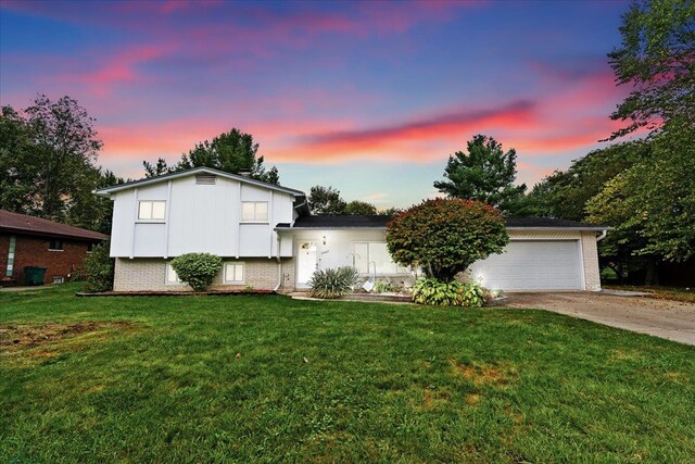 tri-level home featuring a yard and a garage