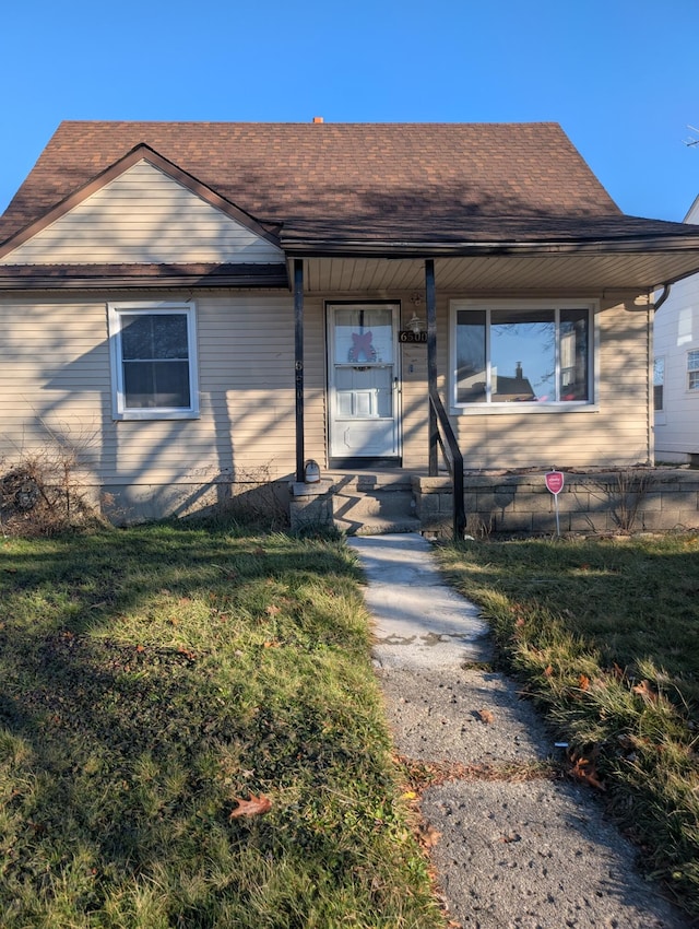 view of front of property featuring a shingled roof and a front yard