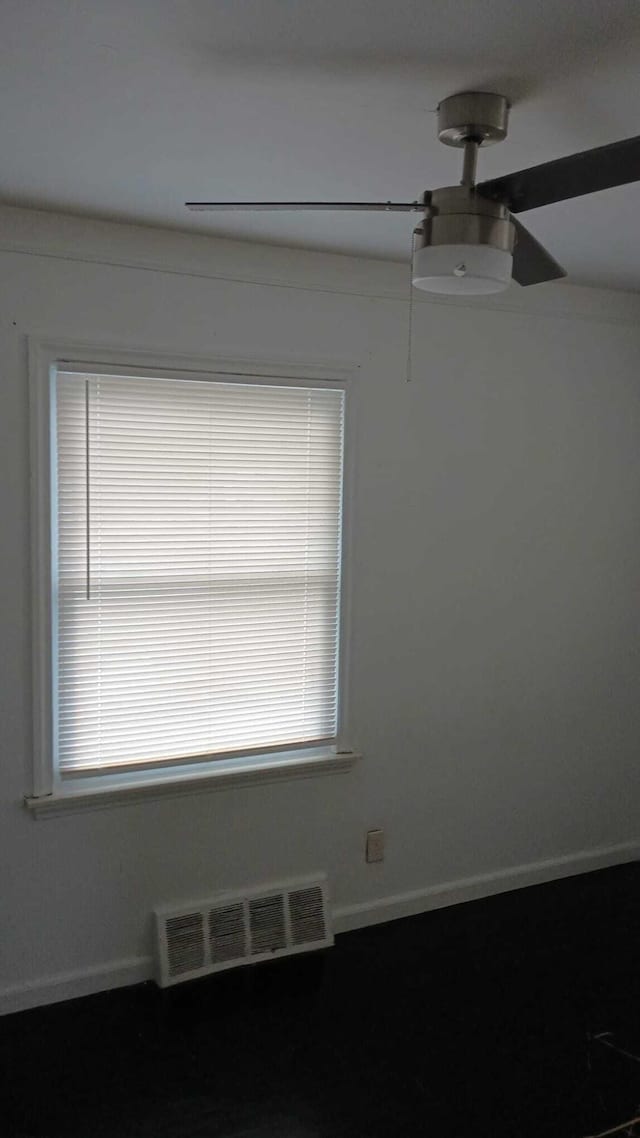 spare room with visible vents, ceiling fan, and baseboards