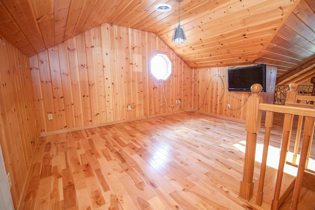 additional living space with wood-type flooring, vaulted ceiling, wood walls, and wood ceiling