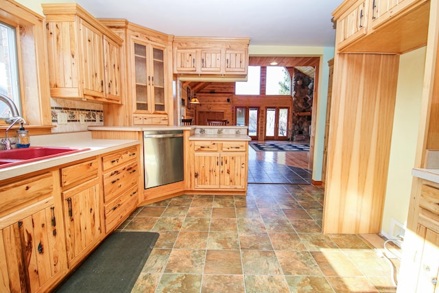 kitchen with dishwasher, light brown cabinets, and sink