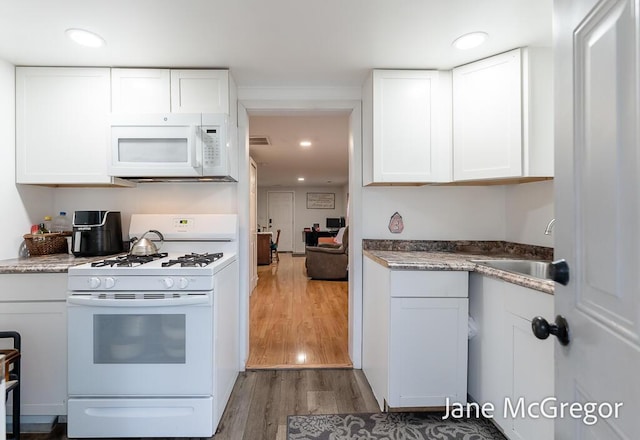 kitchen with white cabinetry, wood-type flooring, white appliances, and sink