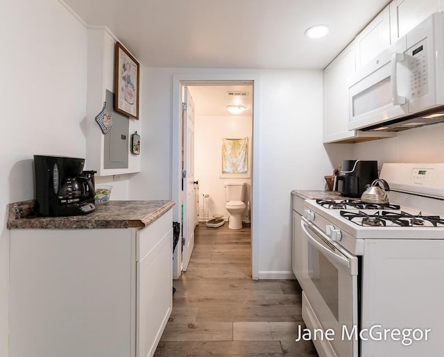 kitchen with white cabinetry, white appliances, and light wood-type flooring