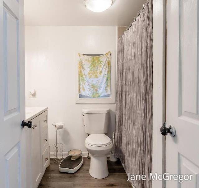 bathroom featuring hardwood / wood-style flooring, vanity, toilet, and a shower with shower curtain