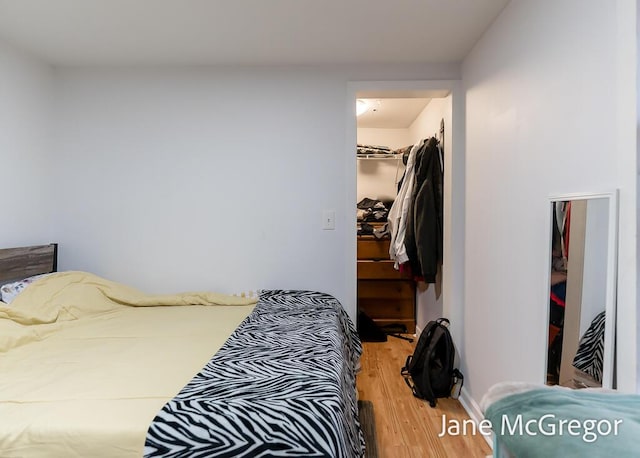 bedroom featuring hardwood / wood-style floors, a walk in closet, and a closet