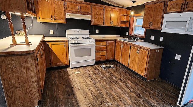 kitchen featuring sink, hanging light fixtures, dark hardwood / wood-style flooring, extractor fan, and white appliances