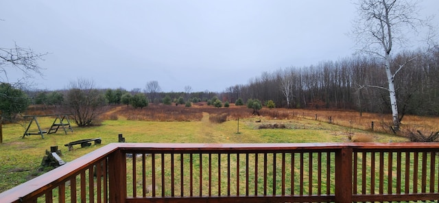 wooden terrace with a lawn and a rural view