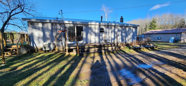 rear view of property with a wooden deck and a yard