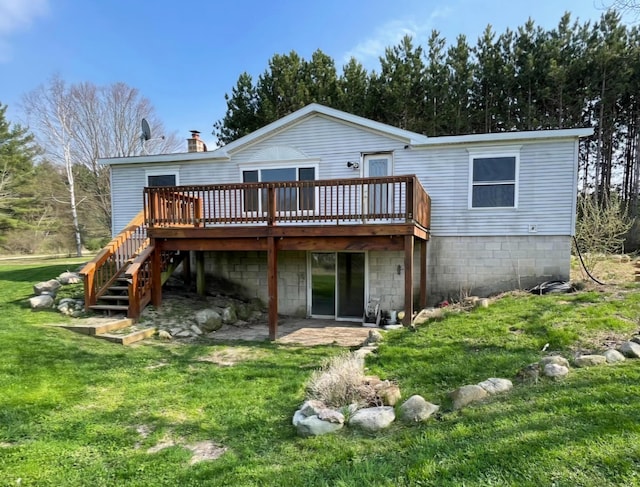 rear view of house featuring a wooden deck and a yard