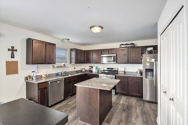 kitchen featuring dark hardwood / wood-style flooring, a center island, stainless steel appliances, and dark brown cabinets