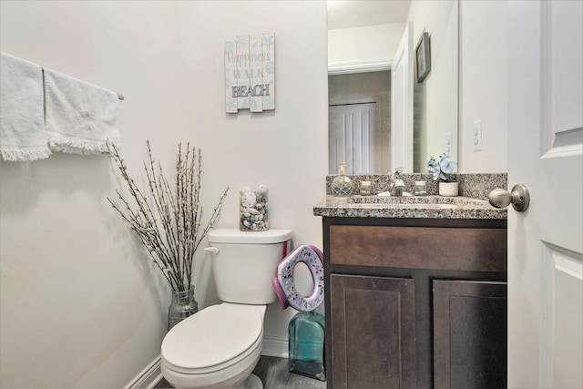 bathroom with vanity, toilet, and wood-type flooring