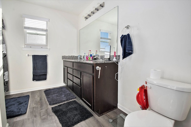 bathroom with hardwood / wood-style floors, vanity, and toilet