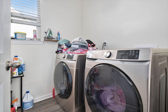 washroom with hardwood / wood-style flooring and washing machine and clothes dryer