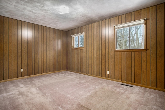 carpeted empty room featuring a textured ceiling