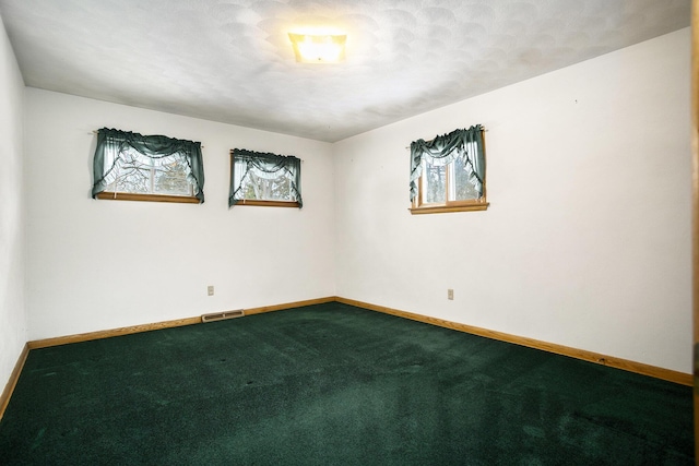 carpeted spare room with a textured ceiling