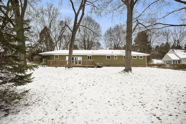 snow covered back of property featuring a wooden deck