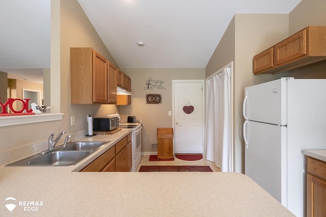 kitchen with lofted ceiling, white appliances, and sink