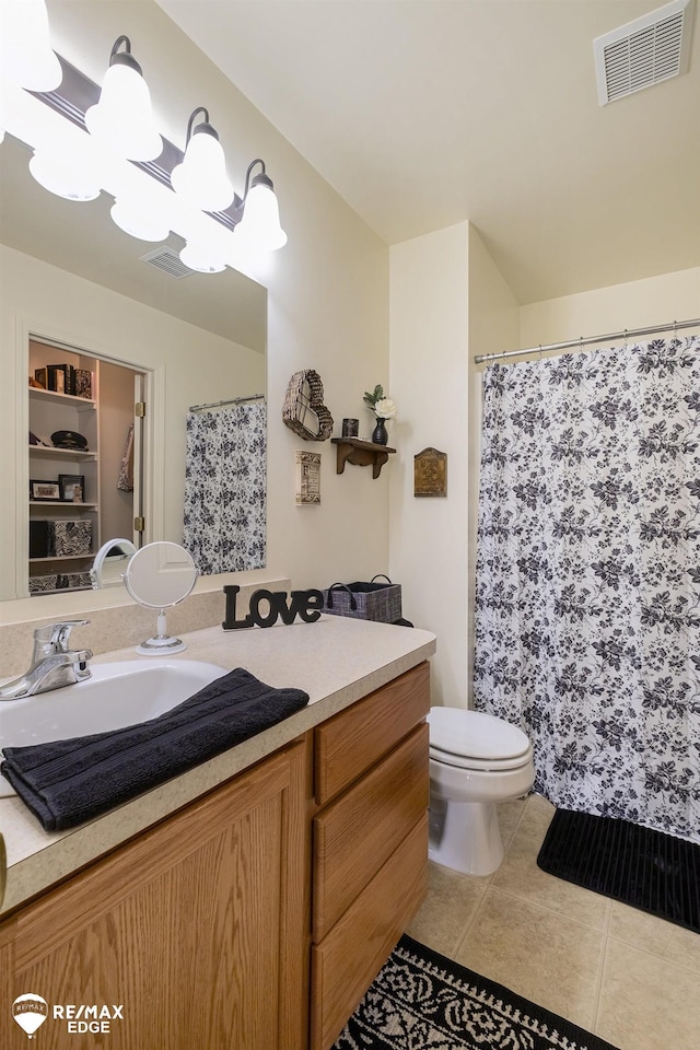 bathroom with tile patterned flooring, vanity, a notable chandelier, and toilet