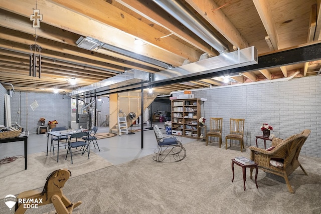 basement featuring brick wall and heating unit