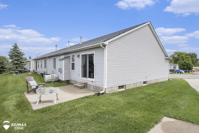 view of side of home featuring a lawn and a patio area