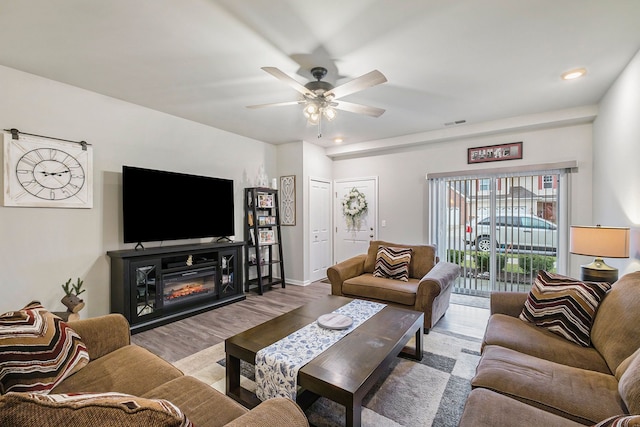 living room with ceiling fan and light wood-type flooring