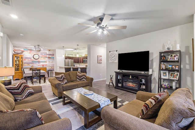 living room featuring a fireplace, hardwood / wood-style floors, and ceiling fan