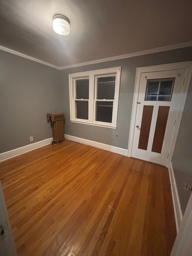 unfurnished room featuring crown molding and hardwood / wood-style floors