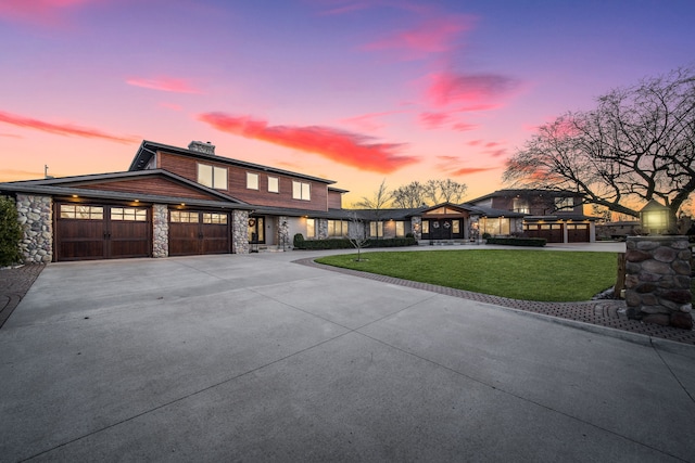 view of front of property with a garage and a yard