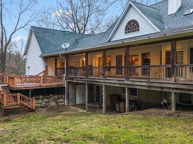 back of property featuring a deck and a lawn