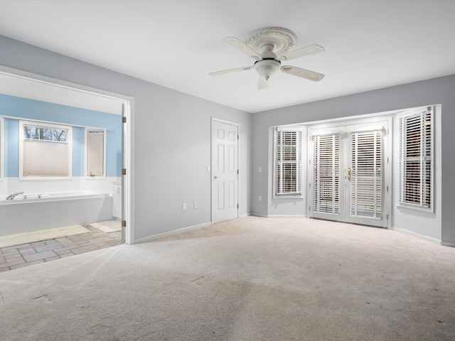 unfurnished bedroom featuring ceiling fan, light carpet, and connected bathroom