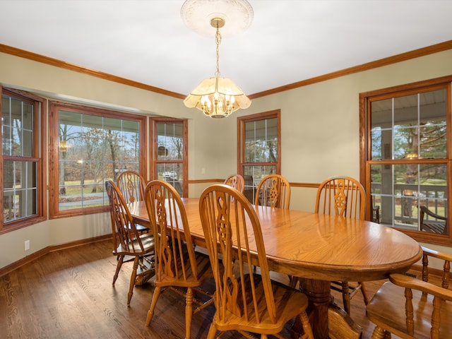 dining area featuring ornamental molding, dark wood-type flooring, and an inviting chandelier