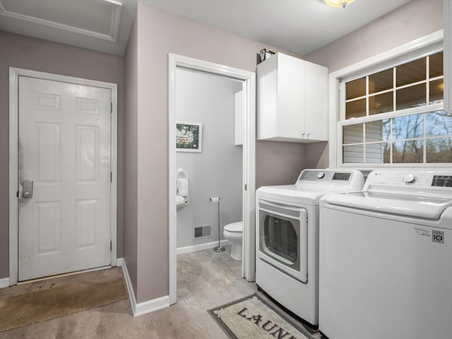 laundry area featuring washer and dryer and cabinets