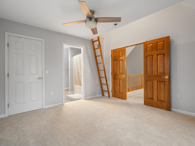 unfurnished bedroom featuring ceiling fan, light colored carpet, and connected bathroom