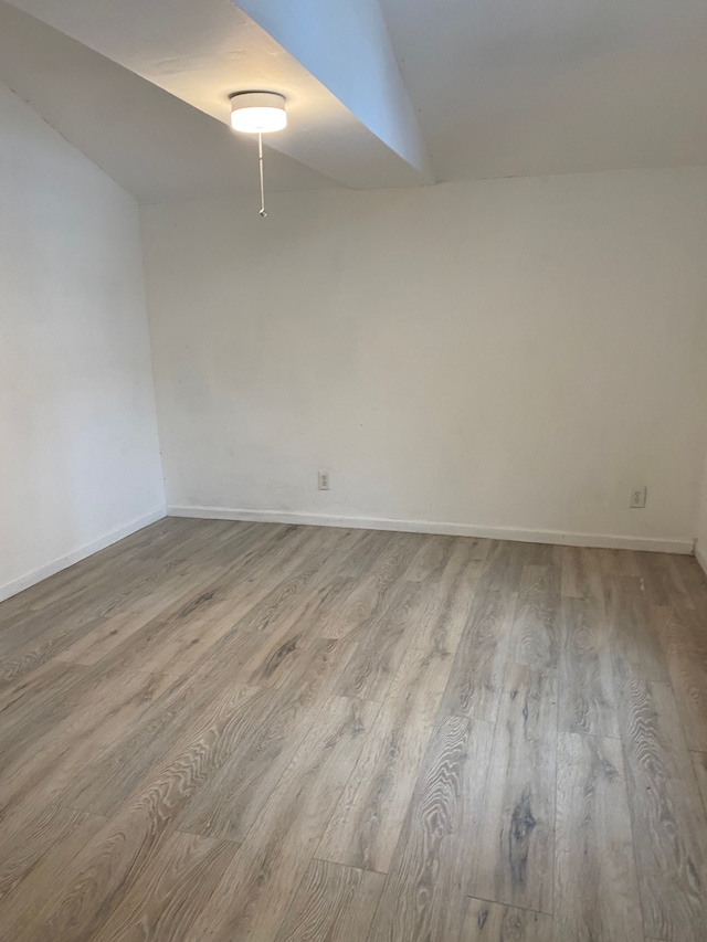 1095 Harding Dr, Grand Blanc, MI 48507 - empty room featuring wood finished floors, baseboards, and vaulted ceiling