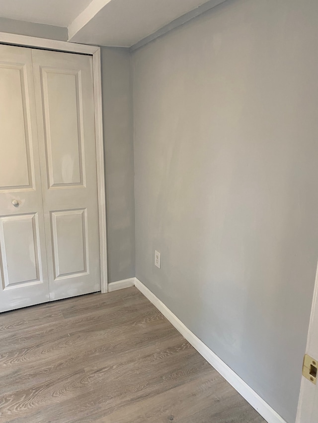 unfurnished bedroom with light hardwood / wood-style floors and a closet