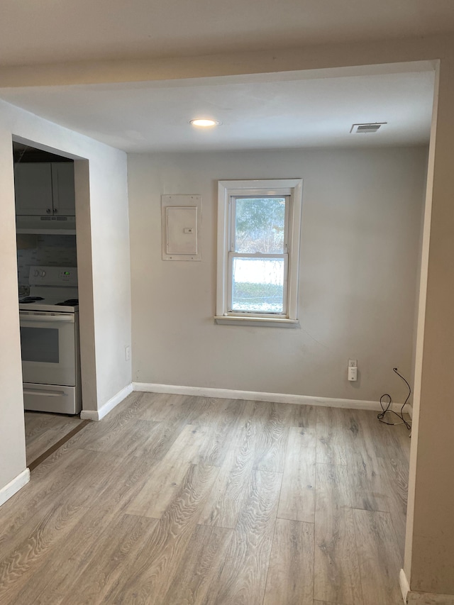 unfurnished room with electric panel and light wood-type flooring