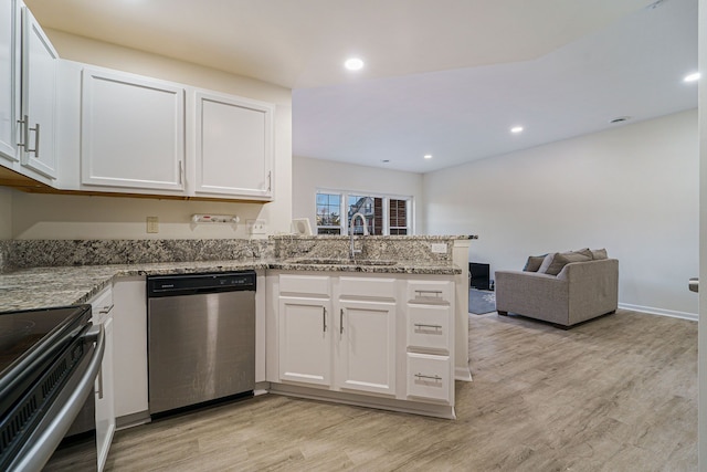 kitchen with stainless steel appliances, sink, white cabinets, and kitchen peninsula